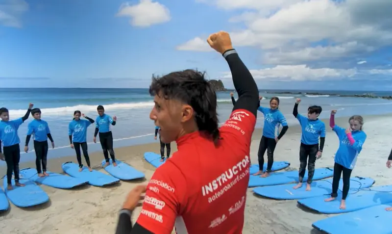 An instructor leads the class warm-up before the morning surf at camp