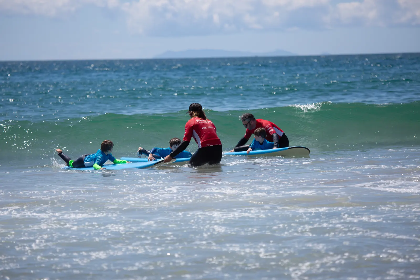 Instructors help junior students catch whitewater waves close to shore