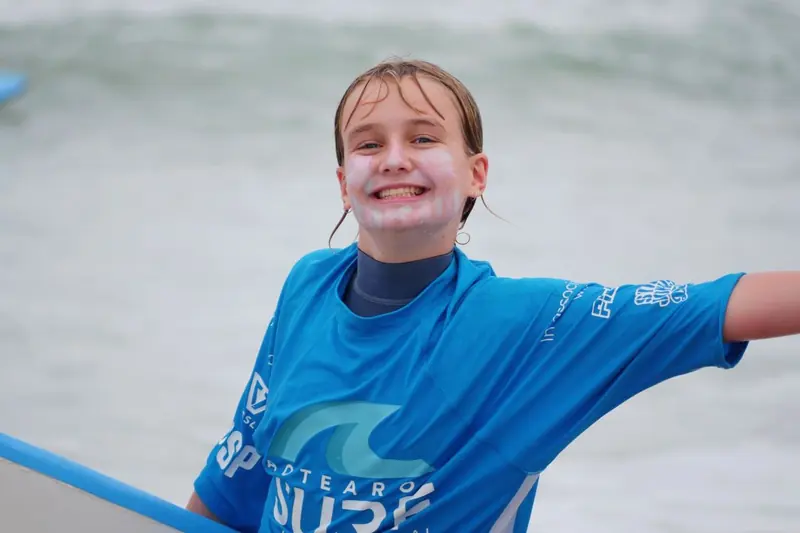 A student grins mid-lesson at Sumner Beach, Christchurch